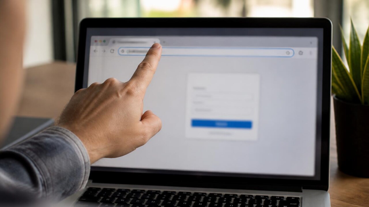 Computador com página de login na tela e mão apontando para a barra de endereços